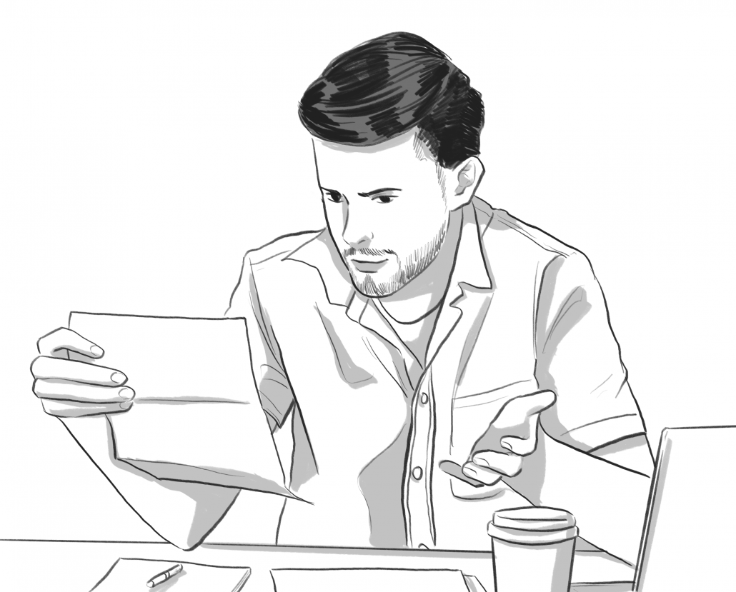 Mann blickt auf ein Blatt Papier vor einem Kaffee und einem Laptop